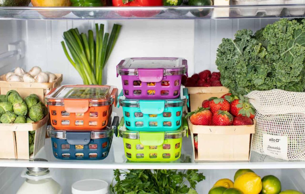 A fridge stocked with fresh vegetables and prepared meals
