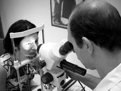 Dr. George examining a patient’s iris through the microscope