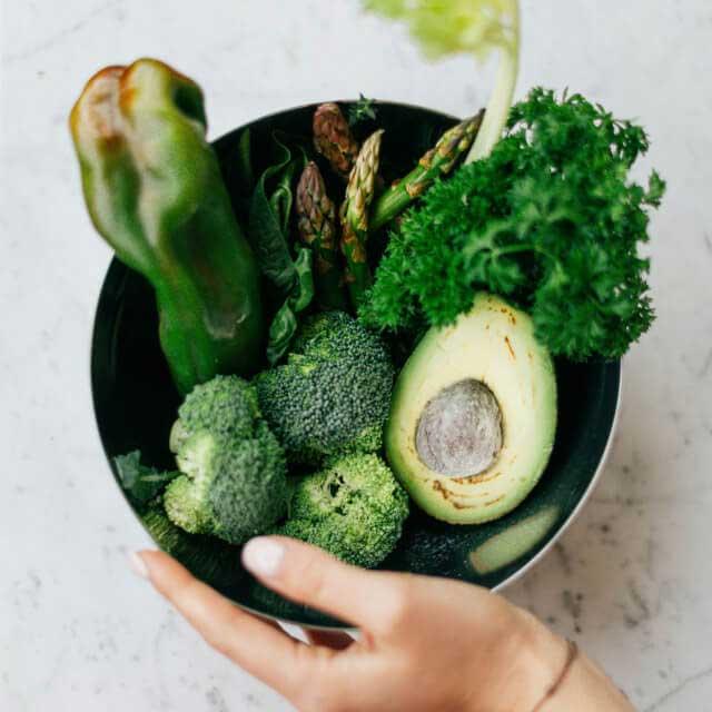 A bowl of fresh vegetables and greens
