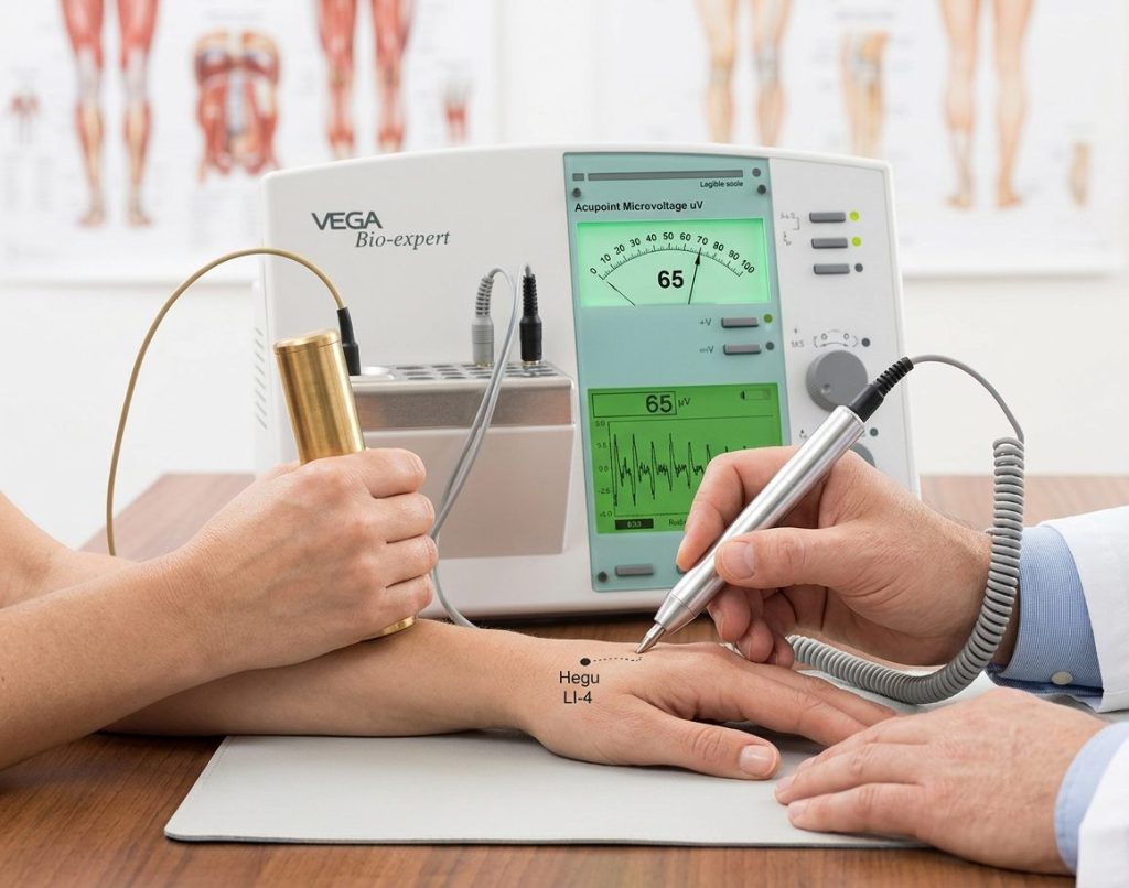The patient holds the brass tube while the practitioner touches an acupuncture point on the hand with the probe